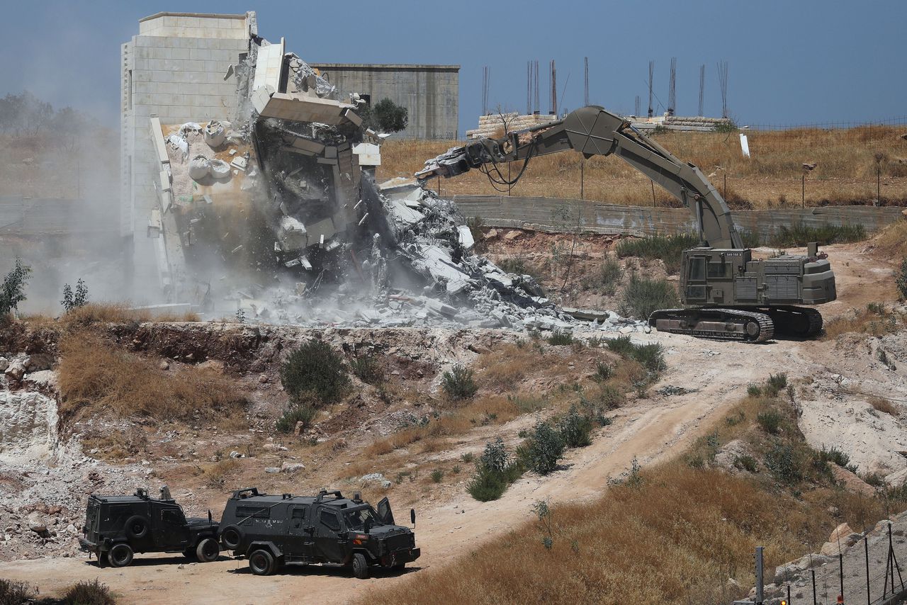 Een Israëlische machine sloopt een gebouw in Sur Baher.