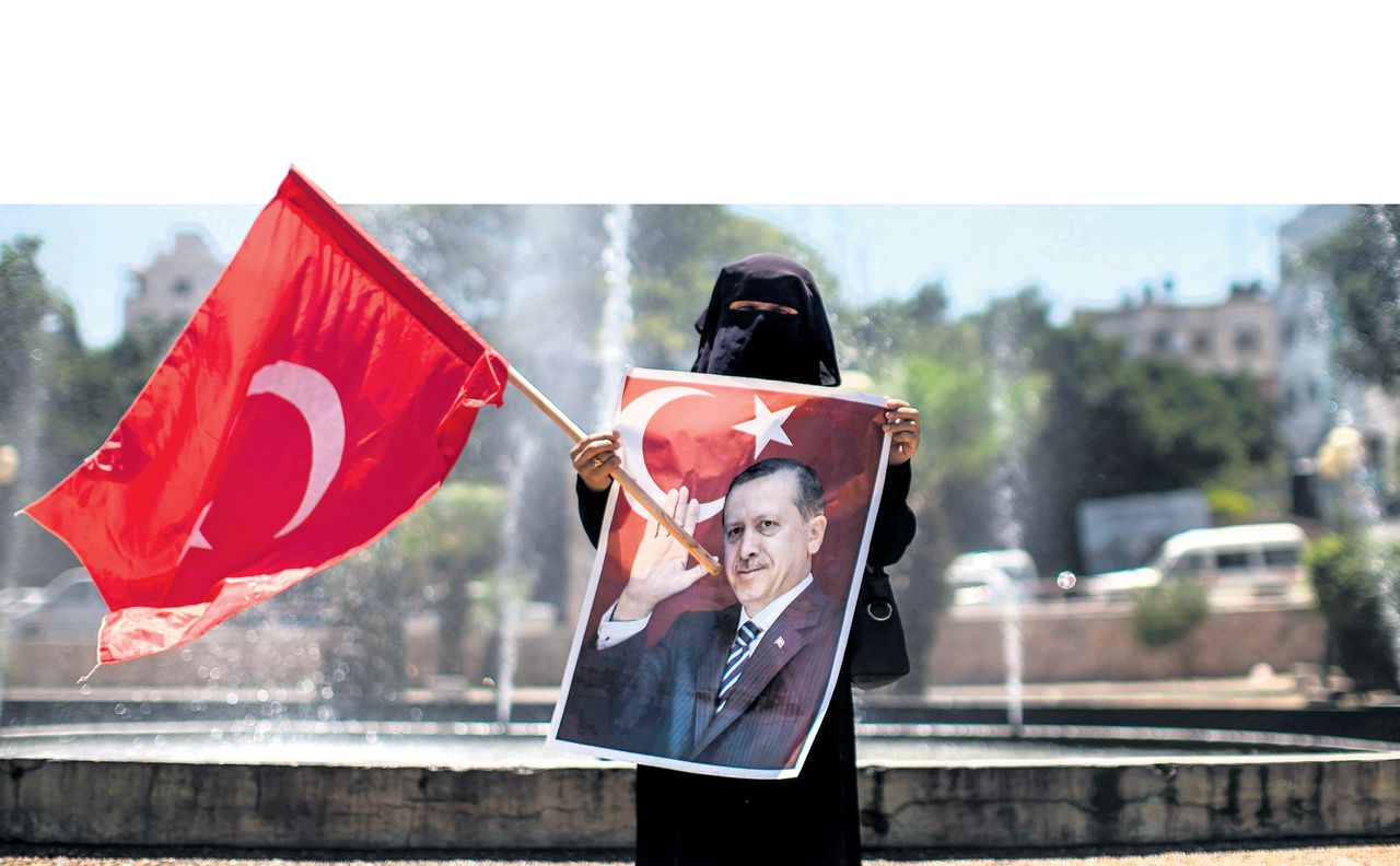 Een Palestijnse vrouw demonstreert tegen de coup in Turkije en laat een portret van Erdogan zien