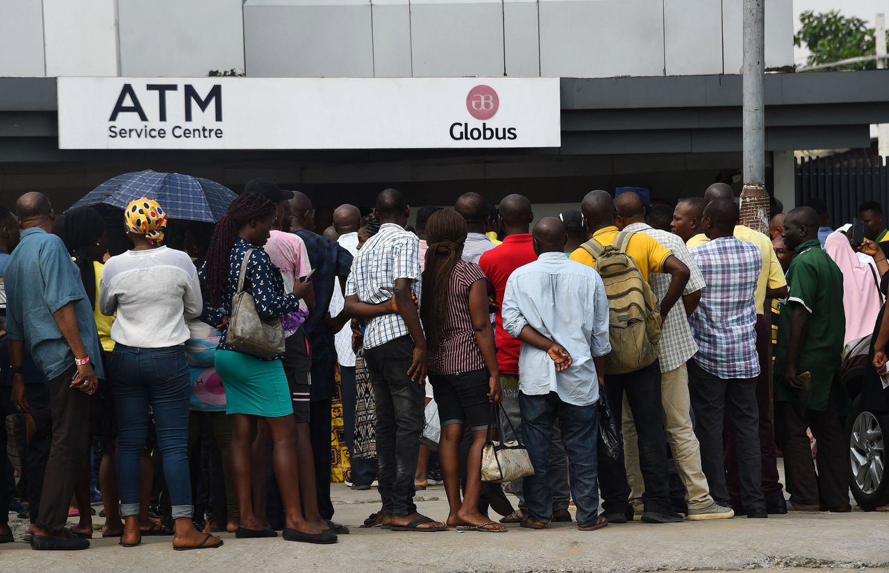 Nigerianen staan in de rij bij een pinautomaat in de hoop wat nieuwe bankbiljetten te bemachtigen.
