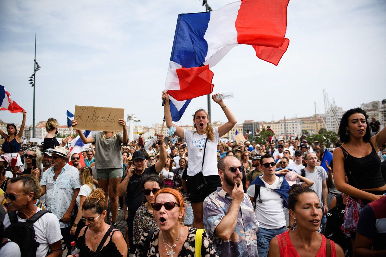 Een protestbord met ‘Vrijheid’ en Franse vlaggen bij een protest in Marseille afgelopen weekend. Meer dan honderdduizend Fransen liepen te hoop tegen de nieuwe coronawet die zondag werd aangenomen.
