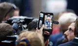 Op de telefoon is Geert Wilders te zien in Venlo tijdens de aftrap van de PVV-campagne voor de Tweede Kamerverkiezingen.