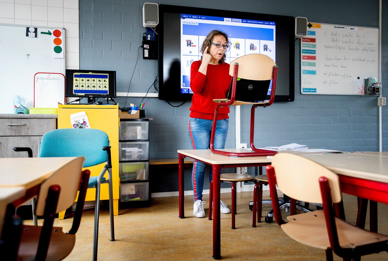 Een lerares geeft onderwijs op afstand. Nog niet duidelijk is hoe lang ze op deze manier les moet geven. Foto Koen van Weel/ANP