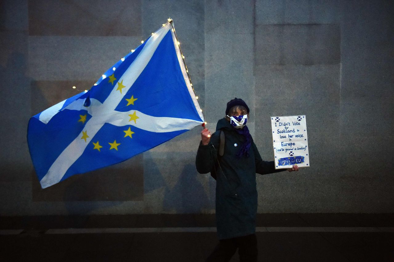 Een anti-Brexit activist, die voor Schotse onafhankelijkheid is, protesteert 31 december 2020 voor het Schotse parlement in Edenburgh
