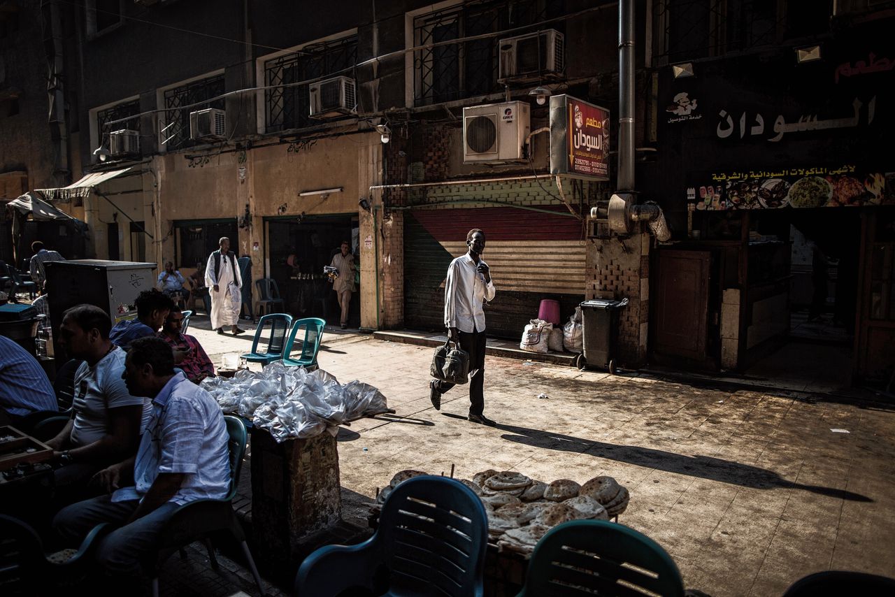 Een man loopt in Caïro langs een café dat populair is onder Soedanese migranten. De Syriërs en daarna de Soedanezen vormen de grootste groep vluchtelingen in Egypte.