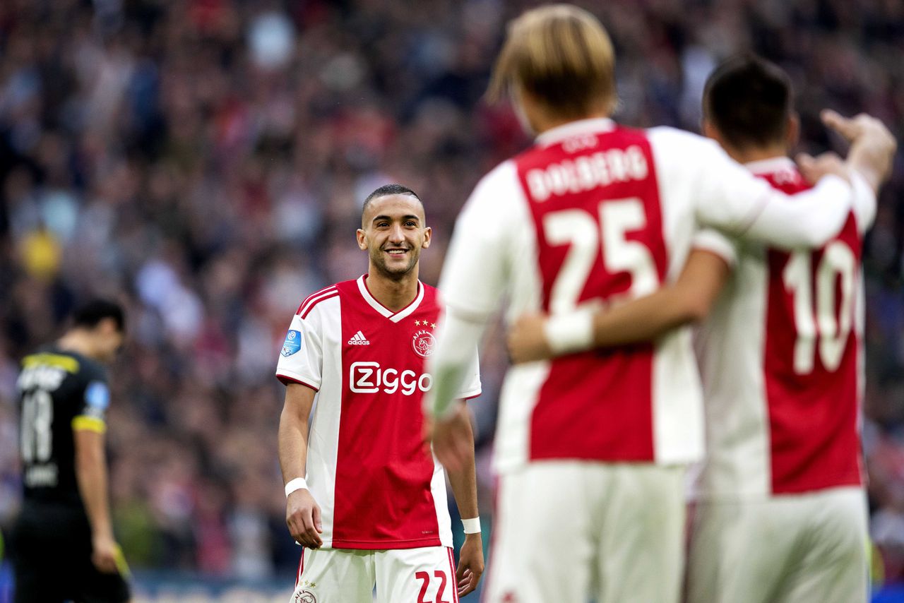 Hakim Ziyech van Ajax loopt naar Kasper Dolberg van Ajax die de 2-0 gescoord heeft.