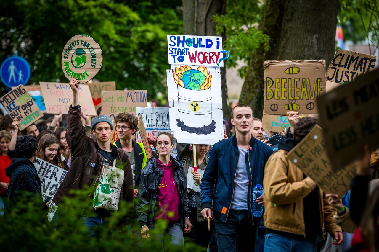 Deelnemers aan een tweede klimaatmars lopen door de Maastrichtse binnenstad. De klimaatactivisten willen dat het klimaatakkoord van Parijs strikt gevolgd wordt door de stad.