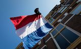 Een Nederlandse vlag met een schooltas.