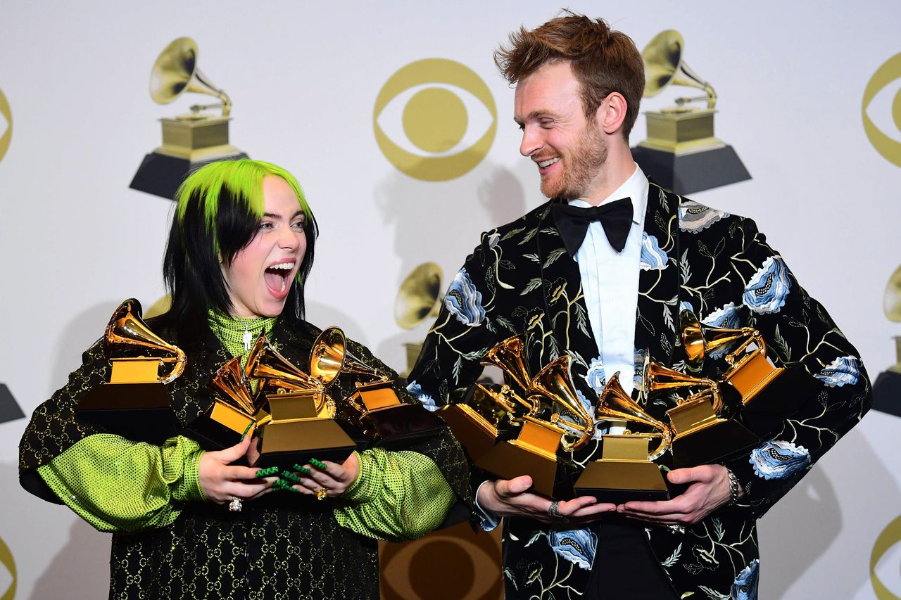 Billie Eilish (links) en haar broer Finneas O'Connell poseren met hun gewonnen Grammy's.