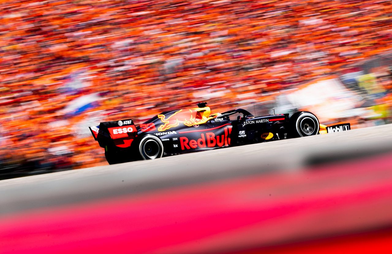 Max Verstappen van Red Bull Racing in actie tijdens de Grand Prix van Oostenrijk in 2019. Achter hem zijn de tribunes oranje gekleurd.