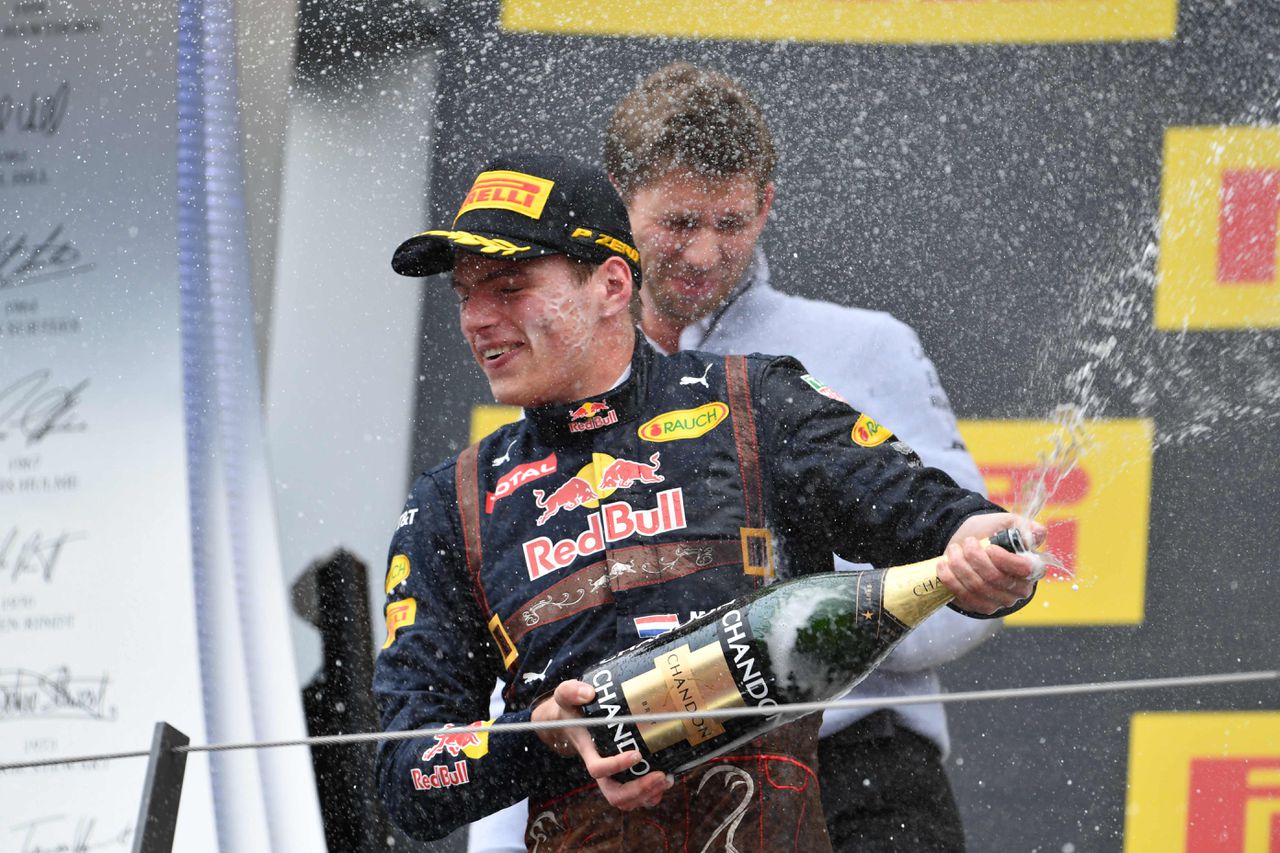 Max Verstappen met de ontkurkte champagne op het podium in Oostenrijk.