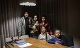 Dmytro Adabir (45) with his wife Hanna (41) and their children, twins Marta and Makar (10) and Marianna (6), in their apartment in Kyiv.
