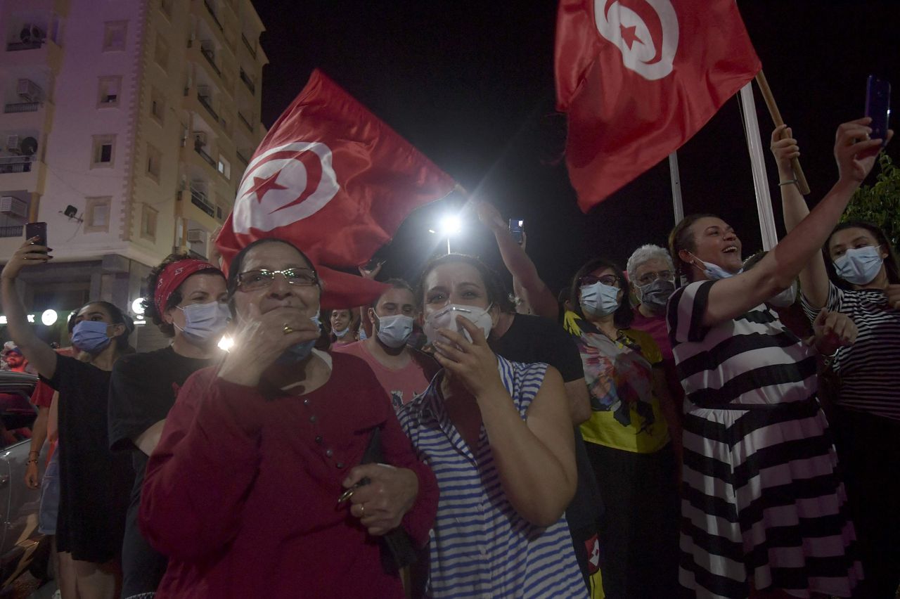 Mensen vieren zondag feest in de Tunesische hoofdstad Tunis, nadat president Kais Saied aankondigde het parlement op te schorten en de regering van premier Hichem Mechichi weg te sturen.