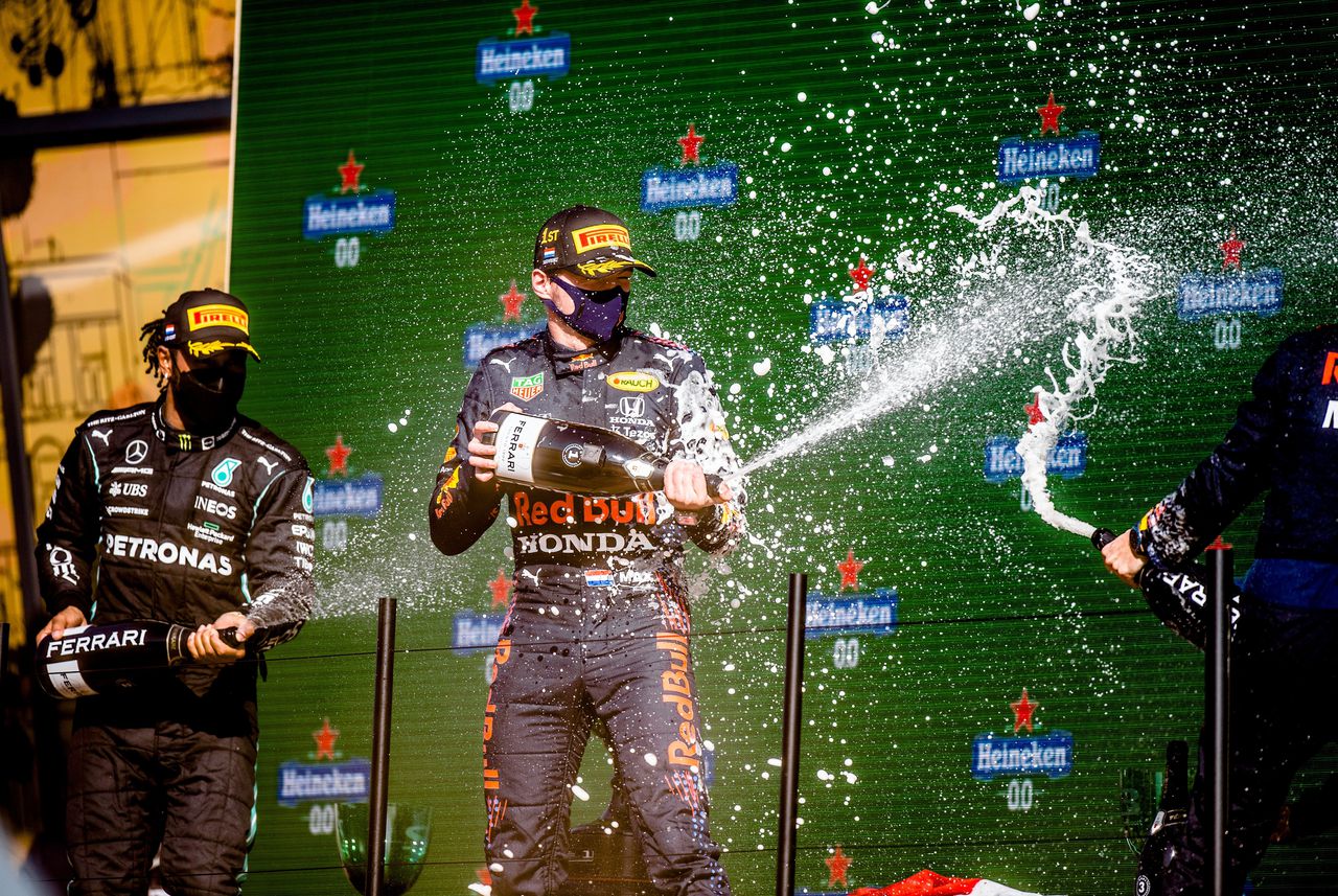 Max Verstappen viert zijn overwinning in de Grote Prijs van Nederland. Links nummer twee Lewis Hamilton.