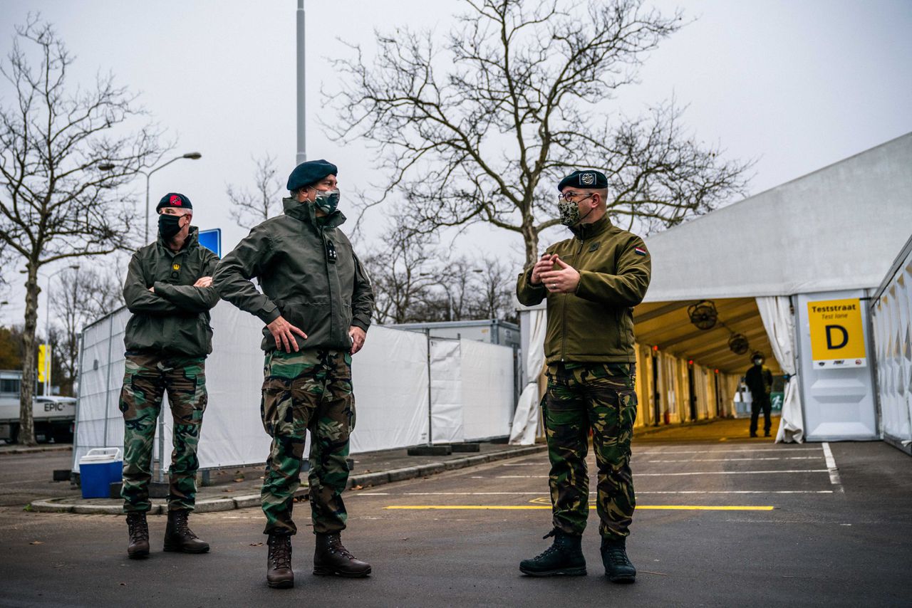 Commandant der Strijdkrachten Rob Bauer in gesprek met een militair in de XL-teststraat in Eindhoven, waar militairen assisteren.