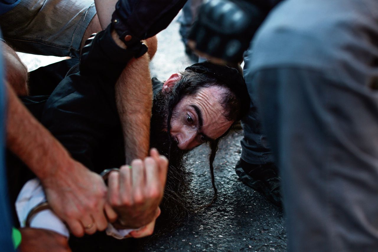 Yishai Schlissel wordt overmeesterd nadat hij zes mensen bij de Gay Pride in Jeruzalem heeft aangevallen met een mes. Foto Emil Salman/AFP