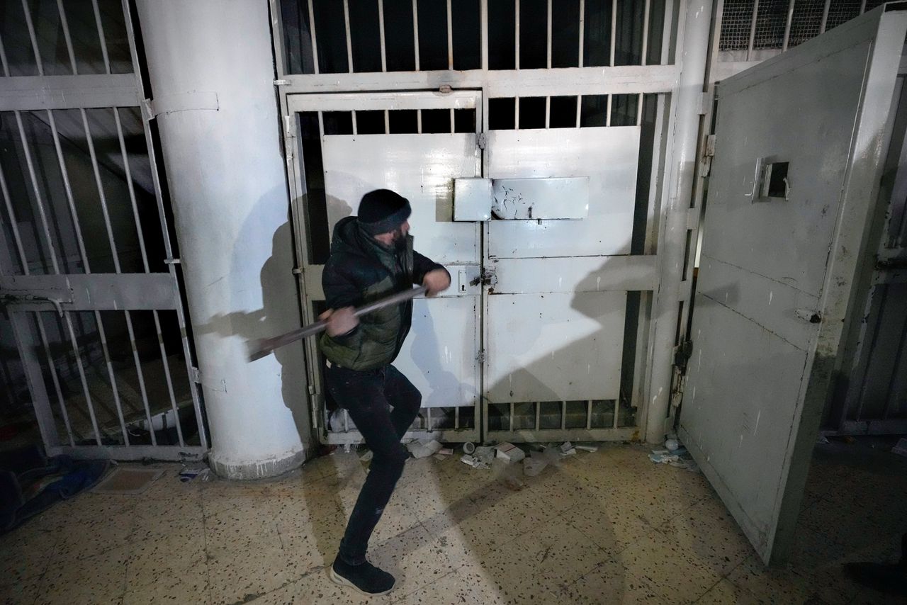 Een man breekt een slot in de beruchte Saydnaya gevangenis, 30 kilometer ten noorden van Damascus. Op maandag 9 december.