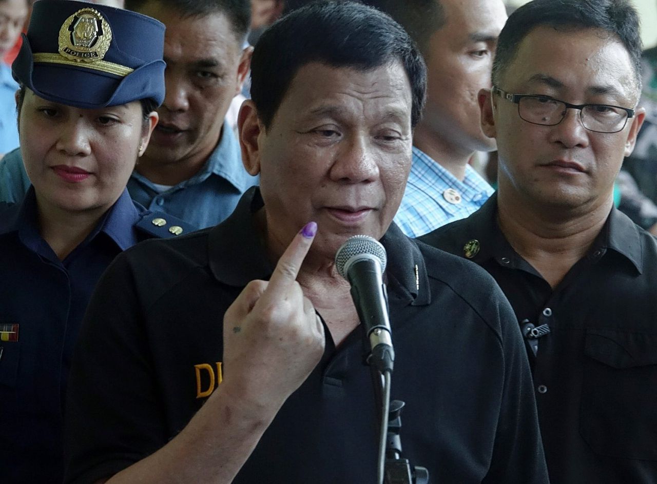 President Duterte laat de inkt op zijn vinger zien nadat hij heeft gestemd bij een basisschool in Davao City.