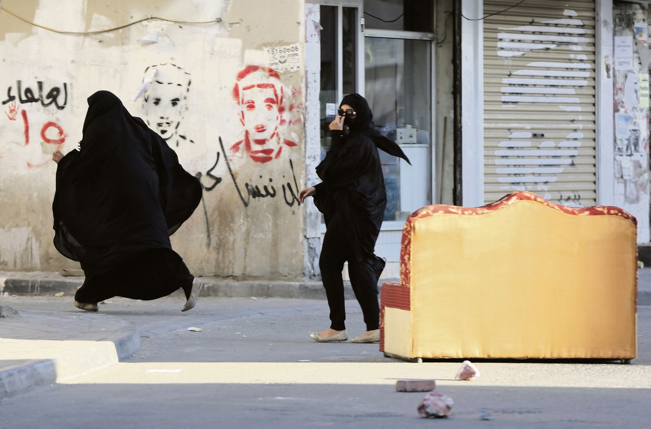Shi'itische vrouwen in Bahrein vluchten voor de politie die een demonstratie tegen de executies in Saoedi-Arabië uiteenslaat.