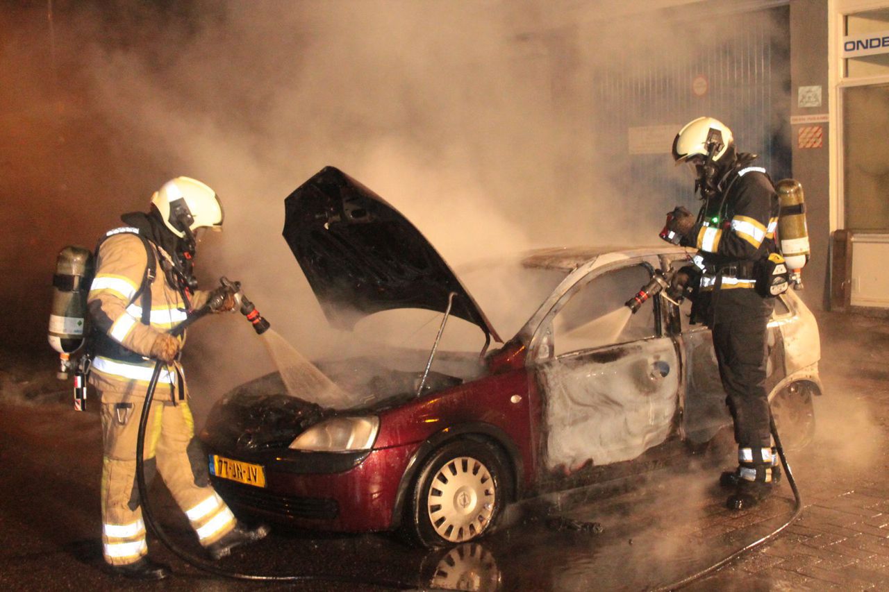 De brandweer blust een auto in de Utrechtse wijk Overvecht.