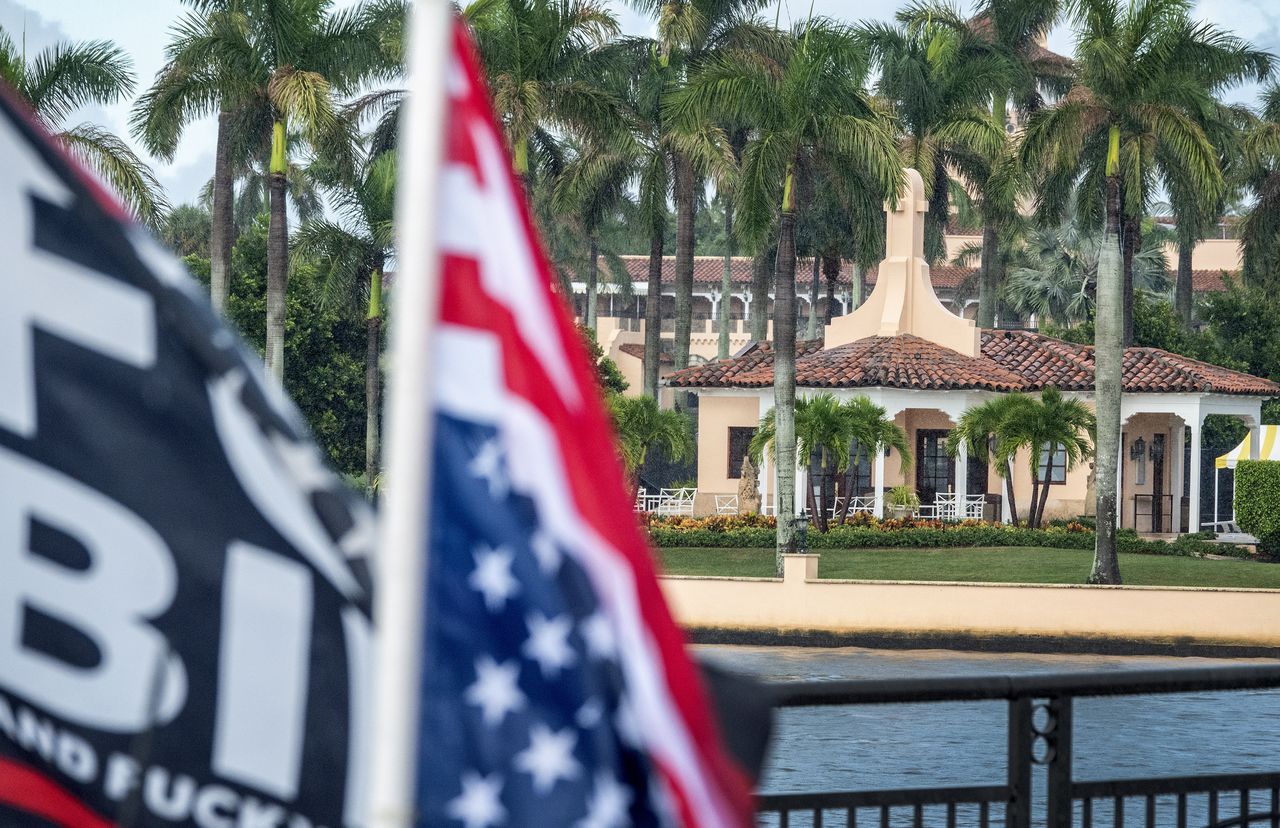 Een aanhanger van voormalig president Donald Trump staat geparkeerd voor Trumps Mar-a-Lago-resort.