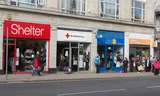 Een rij van vier charity shops, Shelter, British Red Cross, Marie Curie en Arthritis Research UK in de Noord-Engelse plaats Bolton.
