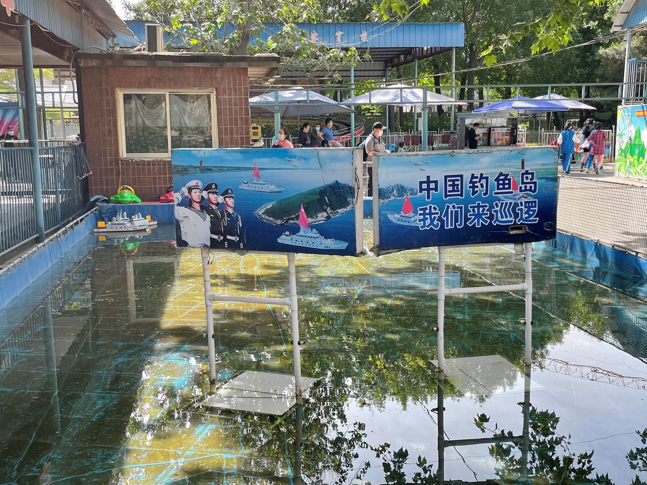 Een attractie met oorlogsbootjes in het Shuangxiu-park in Beijing. „Kom patrouilleren rond de Chinese Diaoyu-eilanden”, staat op het bord.