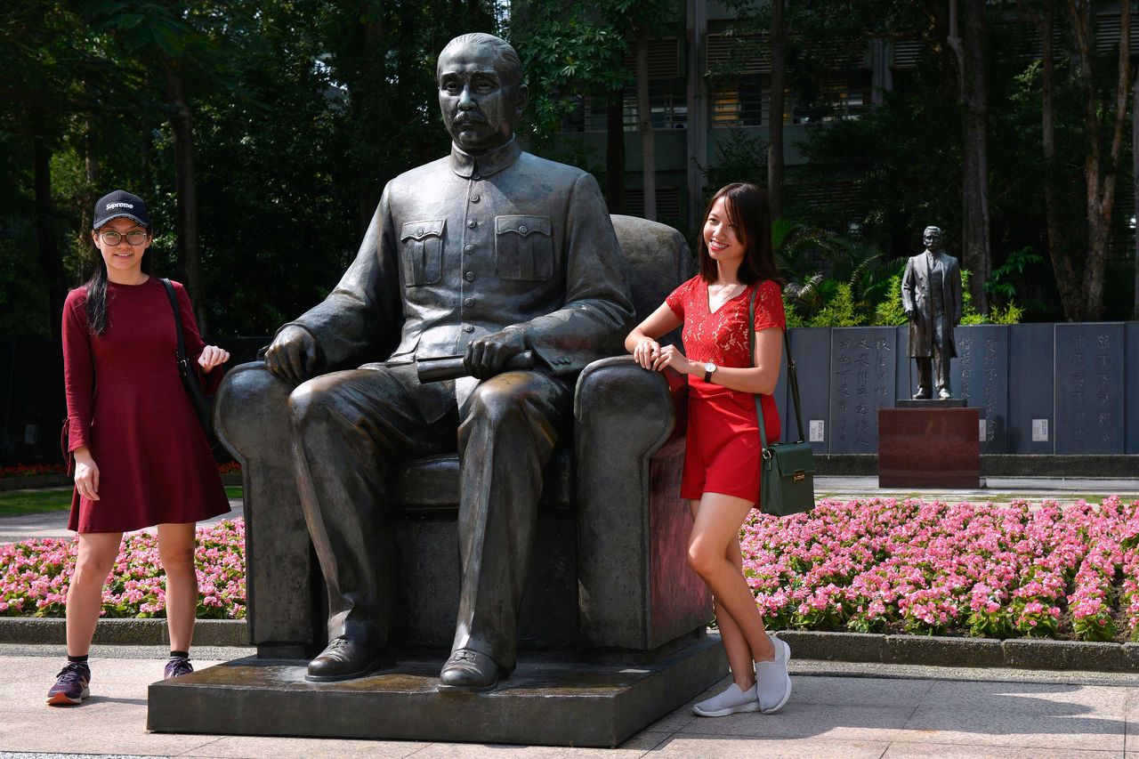 Mensen poseren bij het standbeeld van Sun Yat-Sen/