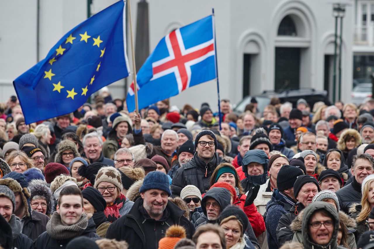 Demonstranten met een vlag van IJsland en een vlag van de EU.