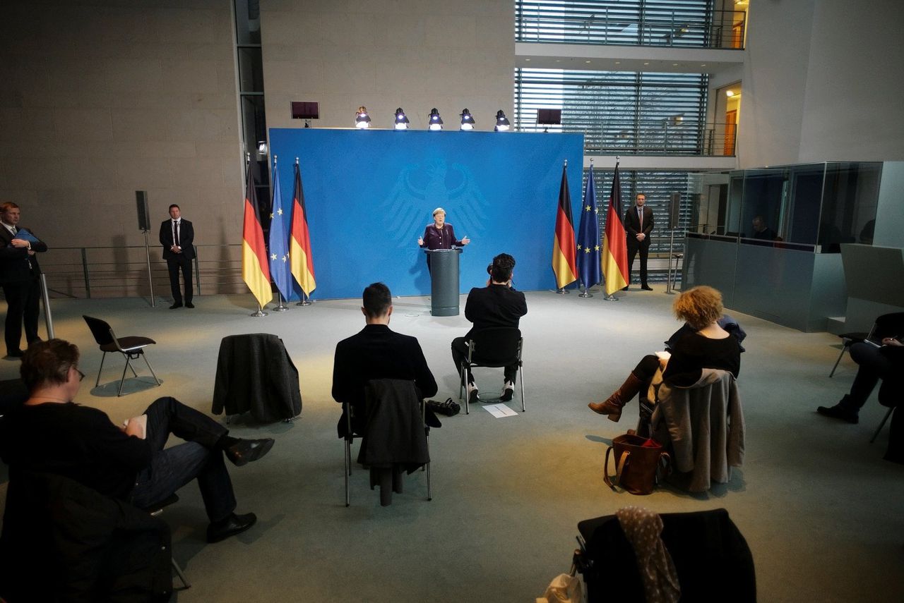Tijdens de persconferentie van Angela Merkel houden journalisten flink afstand.