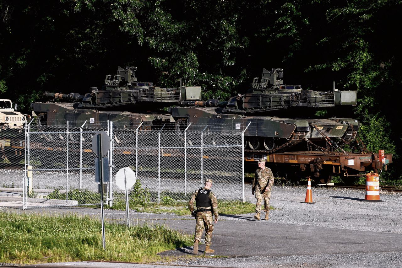 Militairen bij een rangeerterrein vanaf waar Abrams-tanks naar de ceremonieplek voor ‘4 juli’ worden gereden.