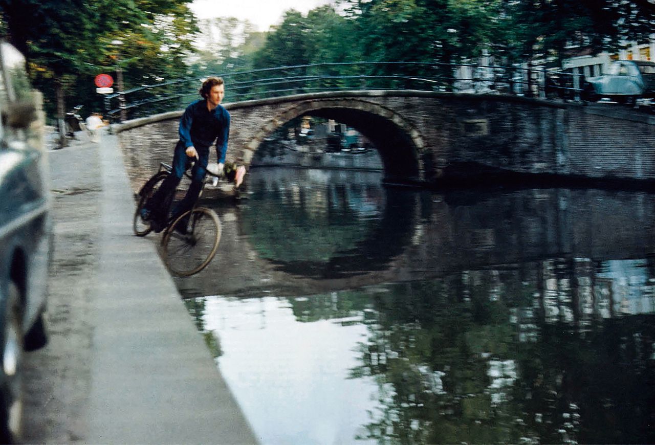 Foto van Bas Jan Ader in 1970, gemaakt bij de opname van zijn 19 seconde durende zwart-witfilm Fall 2, waarbij hij de Amsterdamse Reguliersgracht in fietst.