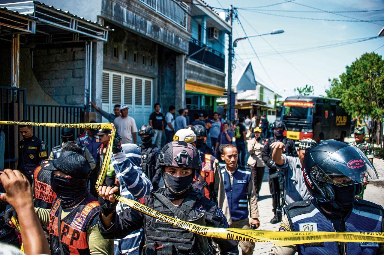 Agenten van een antiterreureenheid bij de woning van een van de families die deze week een aanslag pleegden in Surabaya.