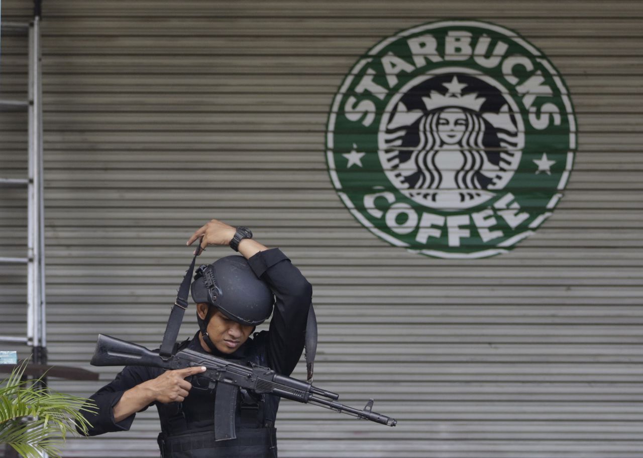 Een Indonesische agent houdt de wacht bij de Starbucks-vestiging waar de aanslag donderdag plaatsvond.