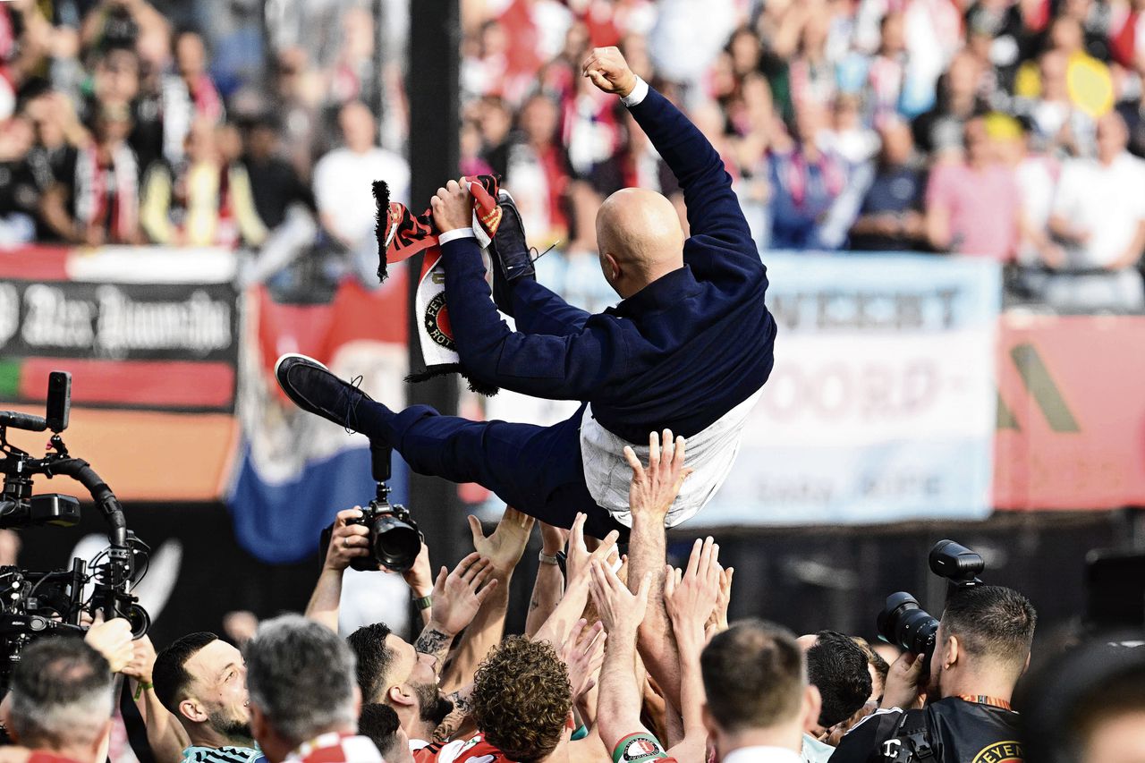 Coach Arne Slot wordt door spelers van Feyenoord in de lucht gegooid na het winnen van de landstitel.