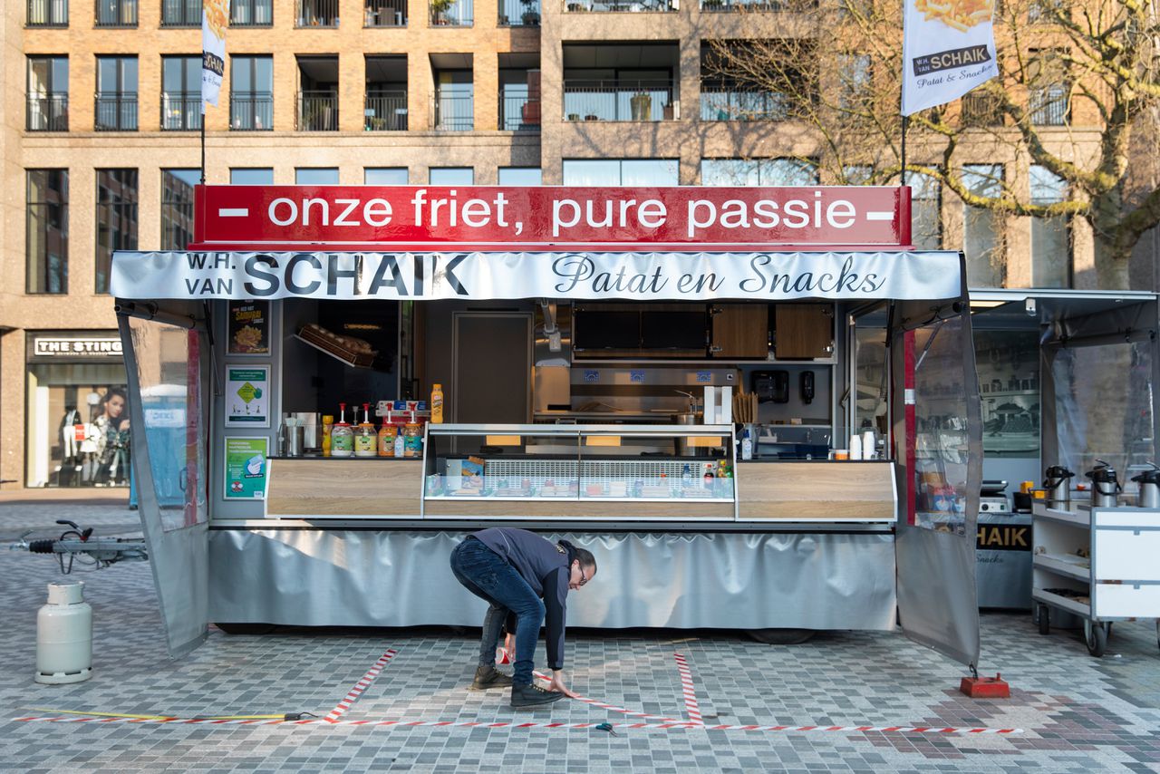 Willem en Hanny van Schaik markeren op de markt in Utrecht de omgeving van hun snackkraam opdat mensen voldoende afstand houden.