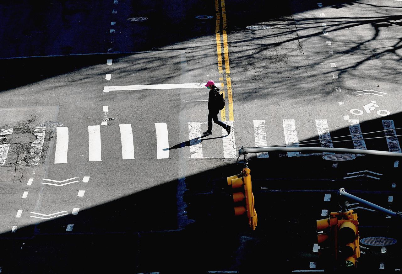 Een persoon steekt de straat over in een leeg New York.