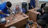 Emergency medical personnel provide care to Russian politician Boris Nadezhdin, second left, accused of displaying „extremist symbols,” during a break at a courtroom in the town of Dolgoprudny, outside Moscow, Russia, Friday, July 17, 2026. (AP Photo/Pavel Bednyakov)