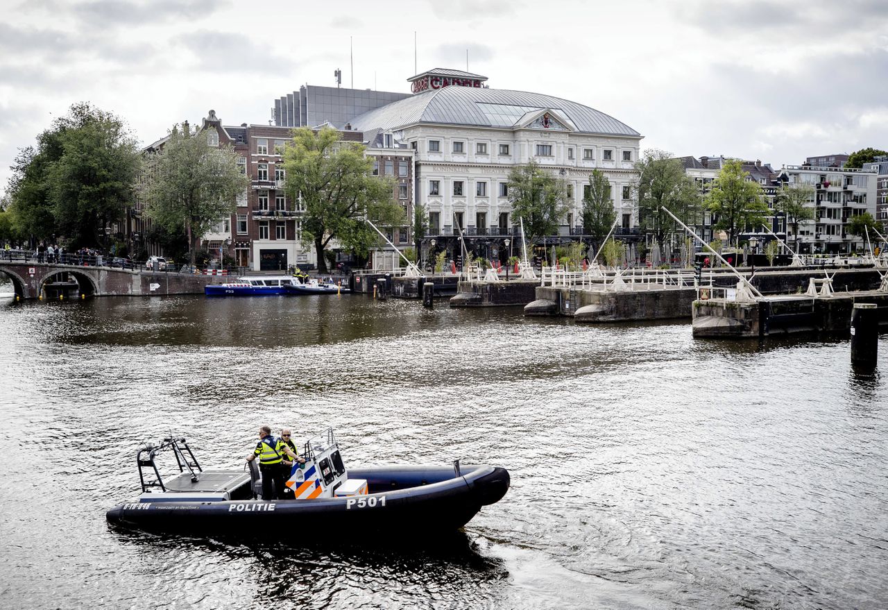 Een politieboot vaart donderdagmorgen op de Amstel bij theater Carré.