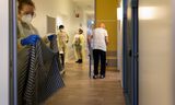 Medewerkers en een bewoner in de gang van verpleeghuis Berkenstede in Diemen (Noord-Holland).