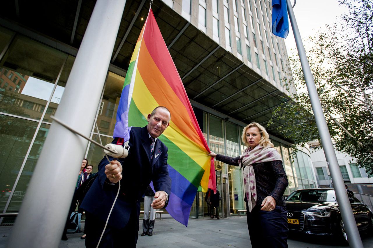 Minister Bussemaker hijst op Coming-Outdag een regenboogvlag bij het ministerie van OCW.