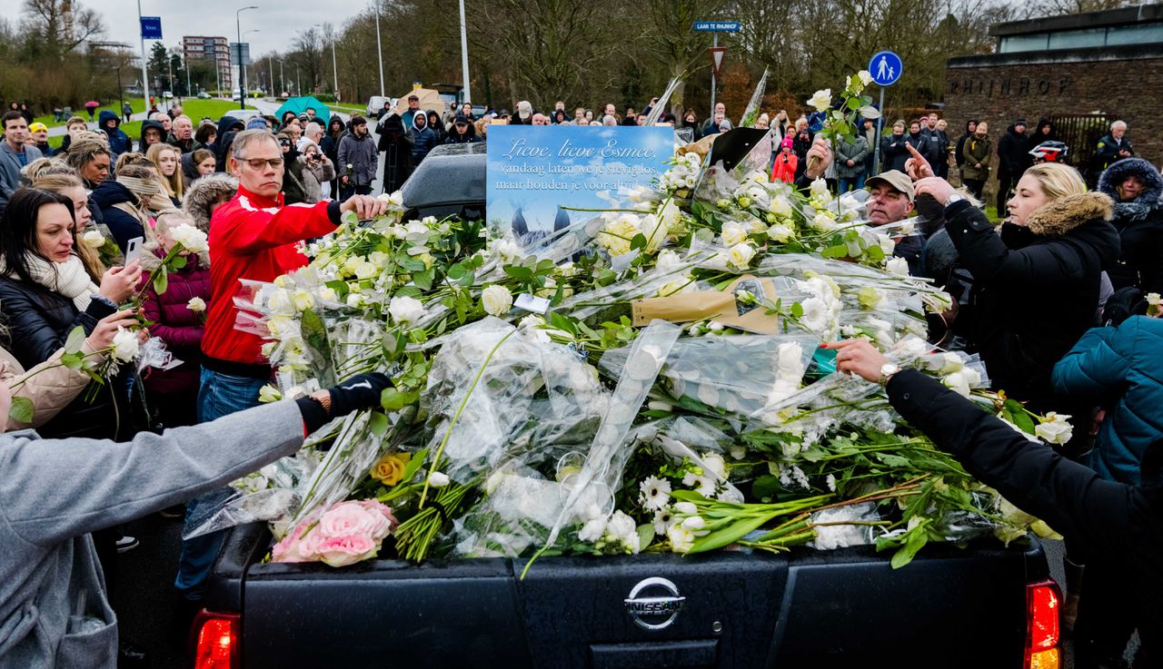 Belangstellenden leggen bloemen op de kist bij de begrafenis van Esmee.