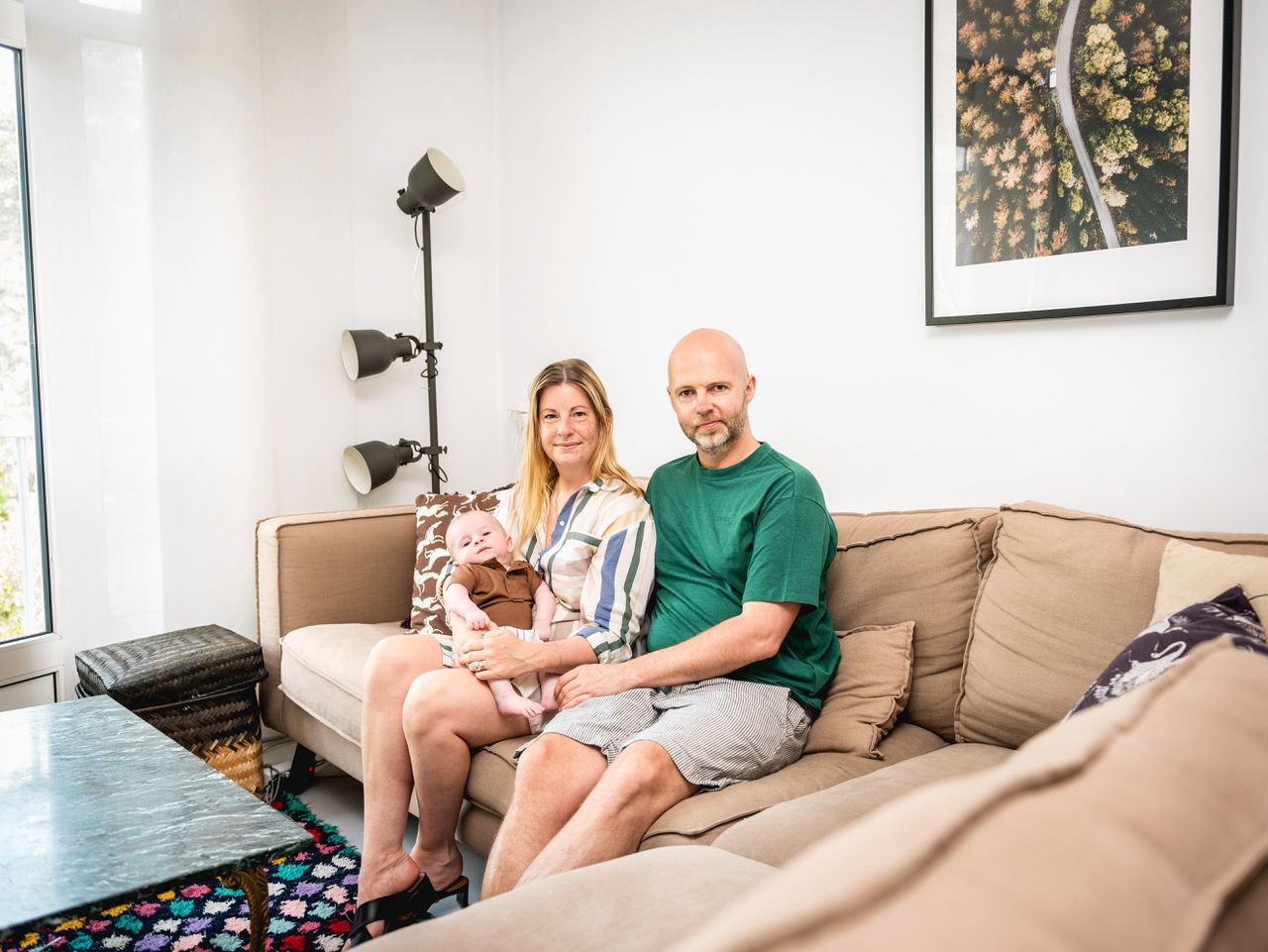 Chris Konijnenburg, zijn vrouw Lauri Stabel en hun baby in hun woonkamer in Amsterdam-Noord.