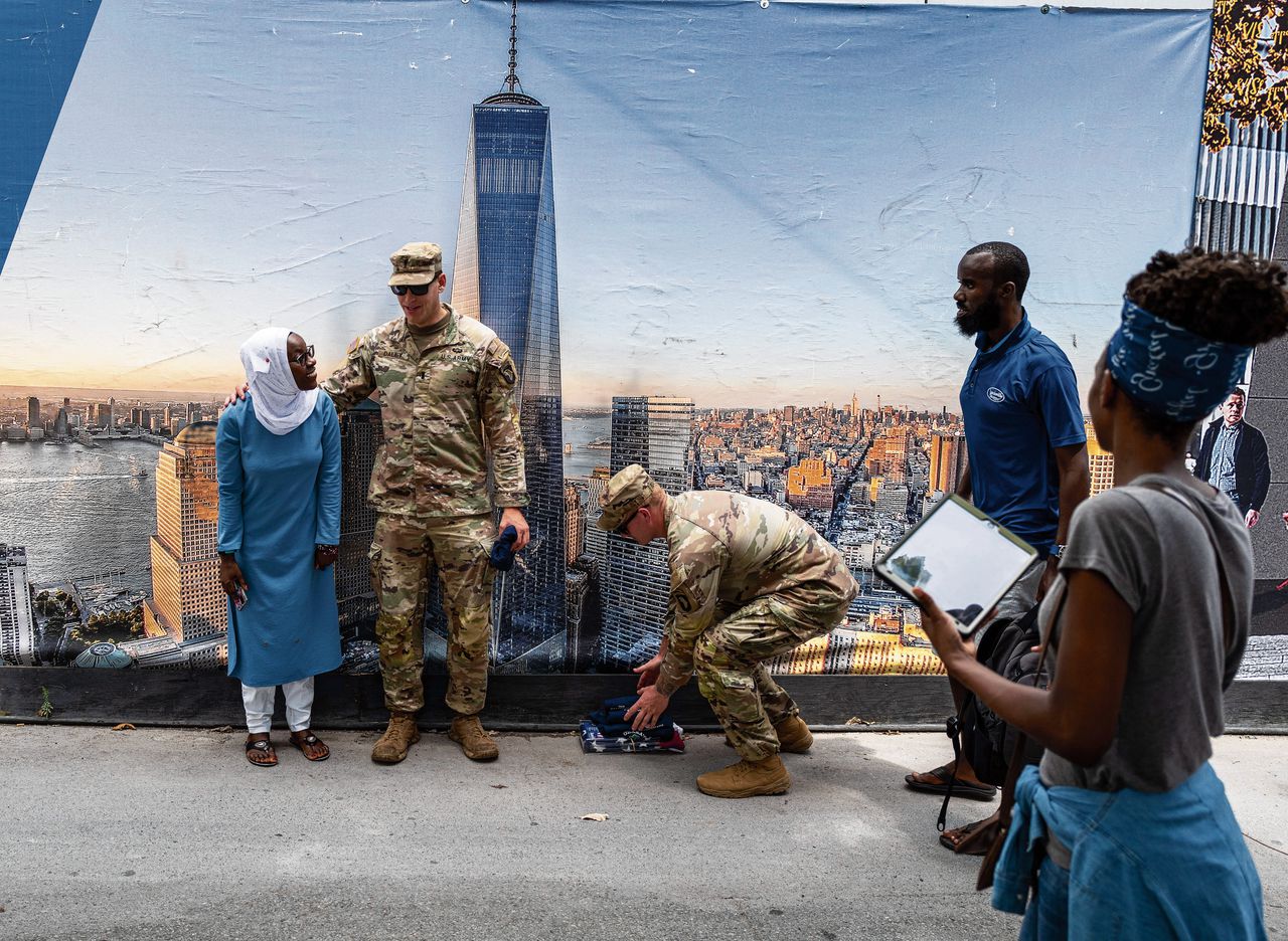 Militairen poseren dinsdag met bezoekers bij het National September 11 Memorial & Museum in New York.