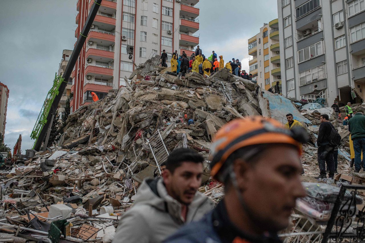 Reddingwerkers zoeken naar overlevenden van de aardbeving tussen het puin van een ingestort gebouw in Adana.