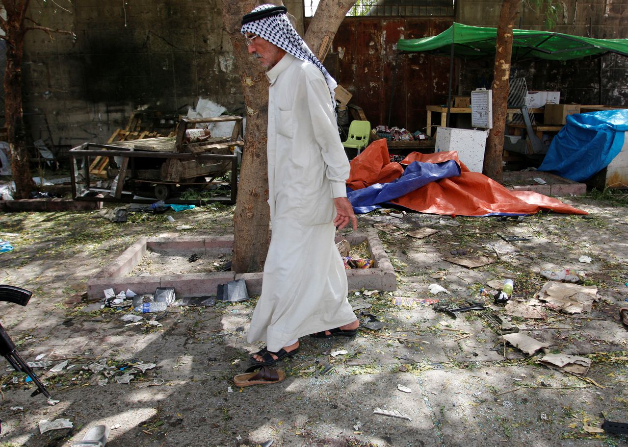 Een man loopt langs de plek waar eerder op de dag een zelfmoordterrorist zichzelf opblies in de Iraakse hoofdstad Bagdad.