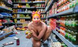 Scène uit de theatrale installatie Alles moet weg van Dries Verhoeven. Je kan tussen de pakken pasta en de potjes augurken naar de actrice gluren. Met het risico dat ze vanachter haar plastic Miss Piggy-maskertje terugkijkt.