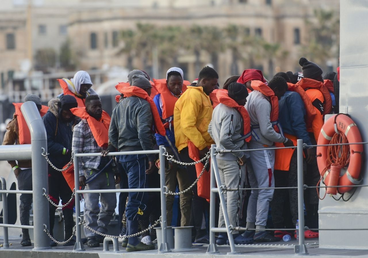 Migranten verlaten in de haven van Valletta een Maltees marineschip, dat hen op de Middellandse Zee heeft opgepikt.