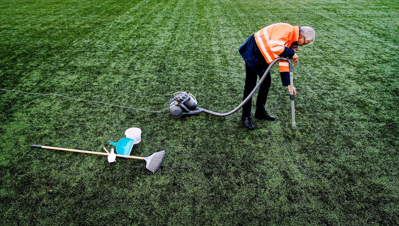 Een medewerker van Vereniging Band en Milieu verzamelt rubberkorrels op een voetbalveld van kunstgras van voetbalvereniging Roda 23. De korrels worden op het laboratorium van de brancheorganisatie getest op de aanwezigheid van kankerverwekkende stoffen.