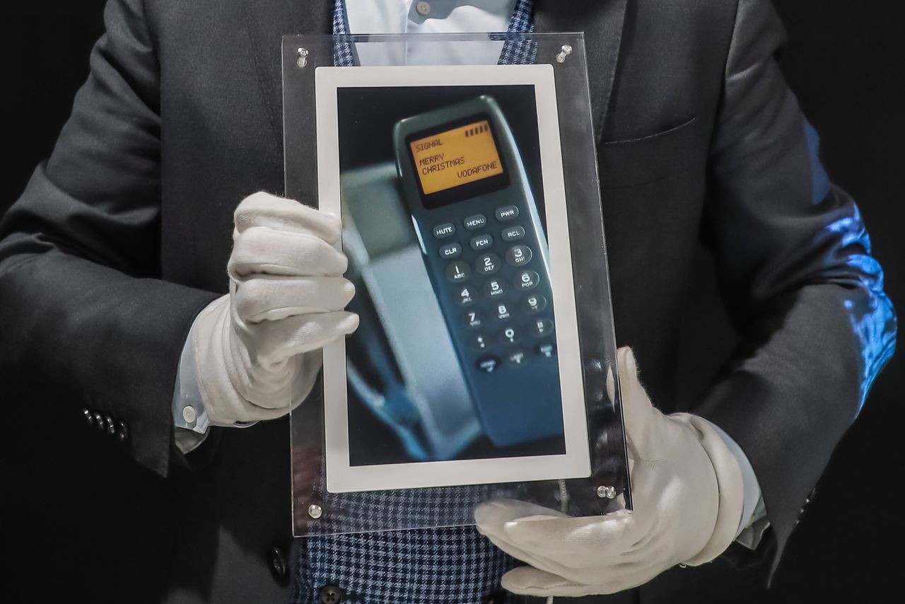 Een foto van een vroege mobiele telefoon met het eerste sms-bericht ooit verstuurd, tijdens een veiling in Parijs in 2021