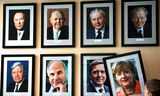 In een Berlijns  café wordt de foto van Angela Merkel opgehangen aan een muur waarop alle naoorlogse Duitse bondkanseliers zijn vereeuwigd.